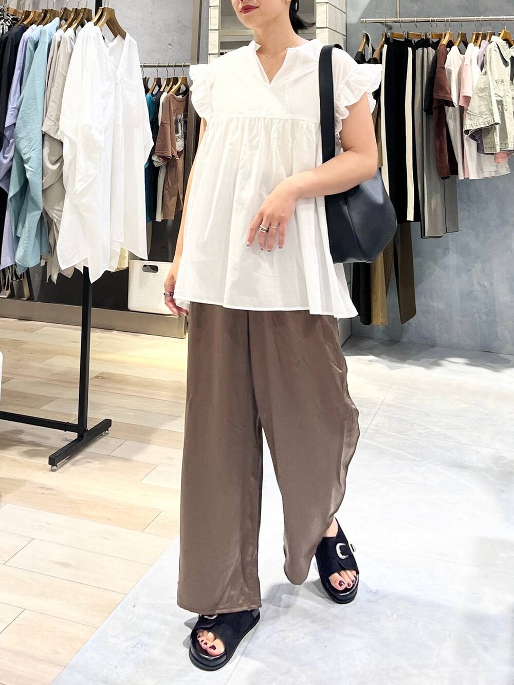 ブラック系のサンダル、ブラウン系のその他パンツ、ブラック系のショルダーバッグを着用したレディースの夏コーディネートの3枚目の写真