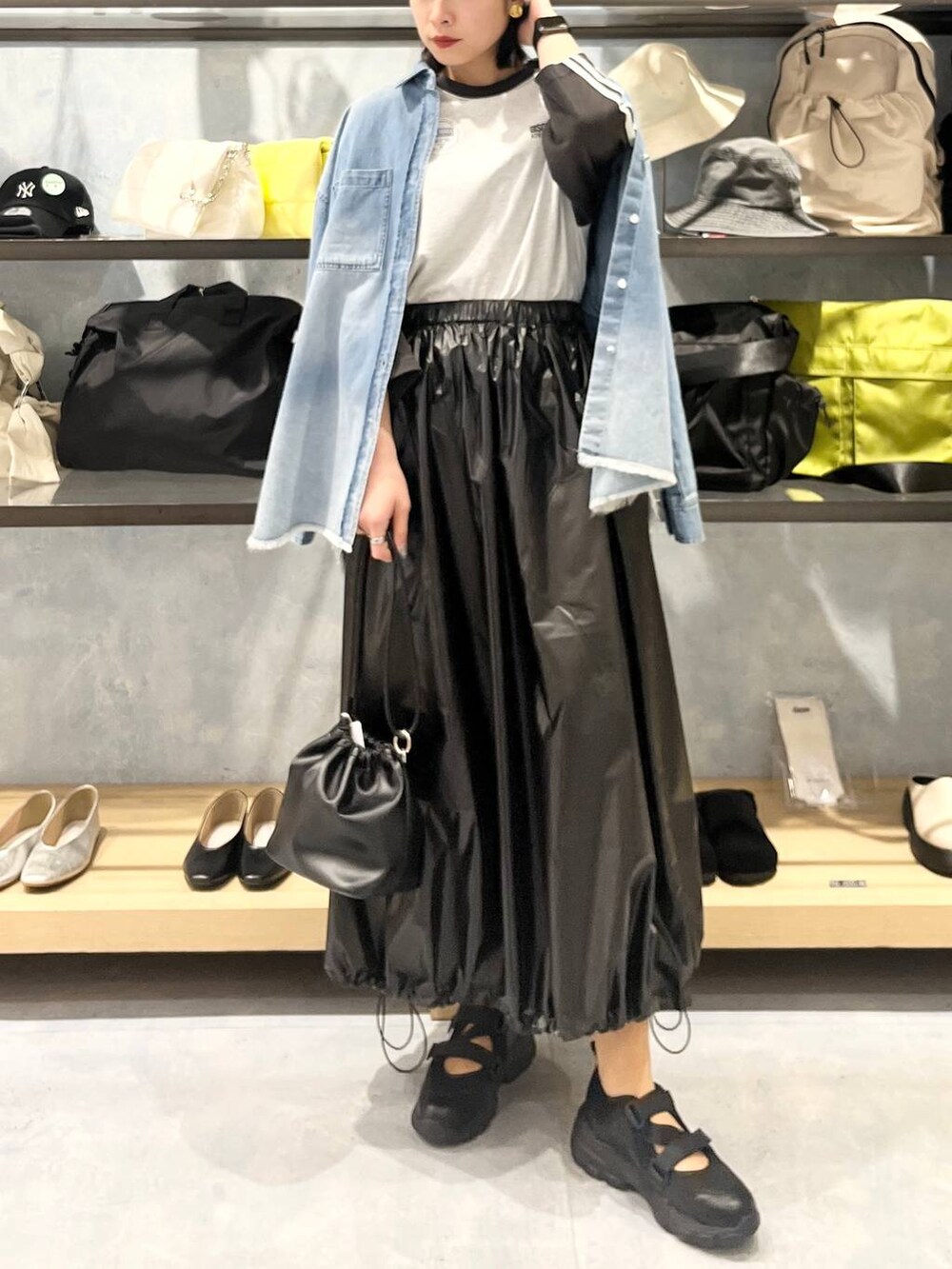 ブラック系のショルダーバッグ、ブラック系のTシャツ/カットソー、ブラック系のスニーカーを着用したレディースの春コーディネートの5枚目の写真