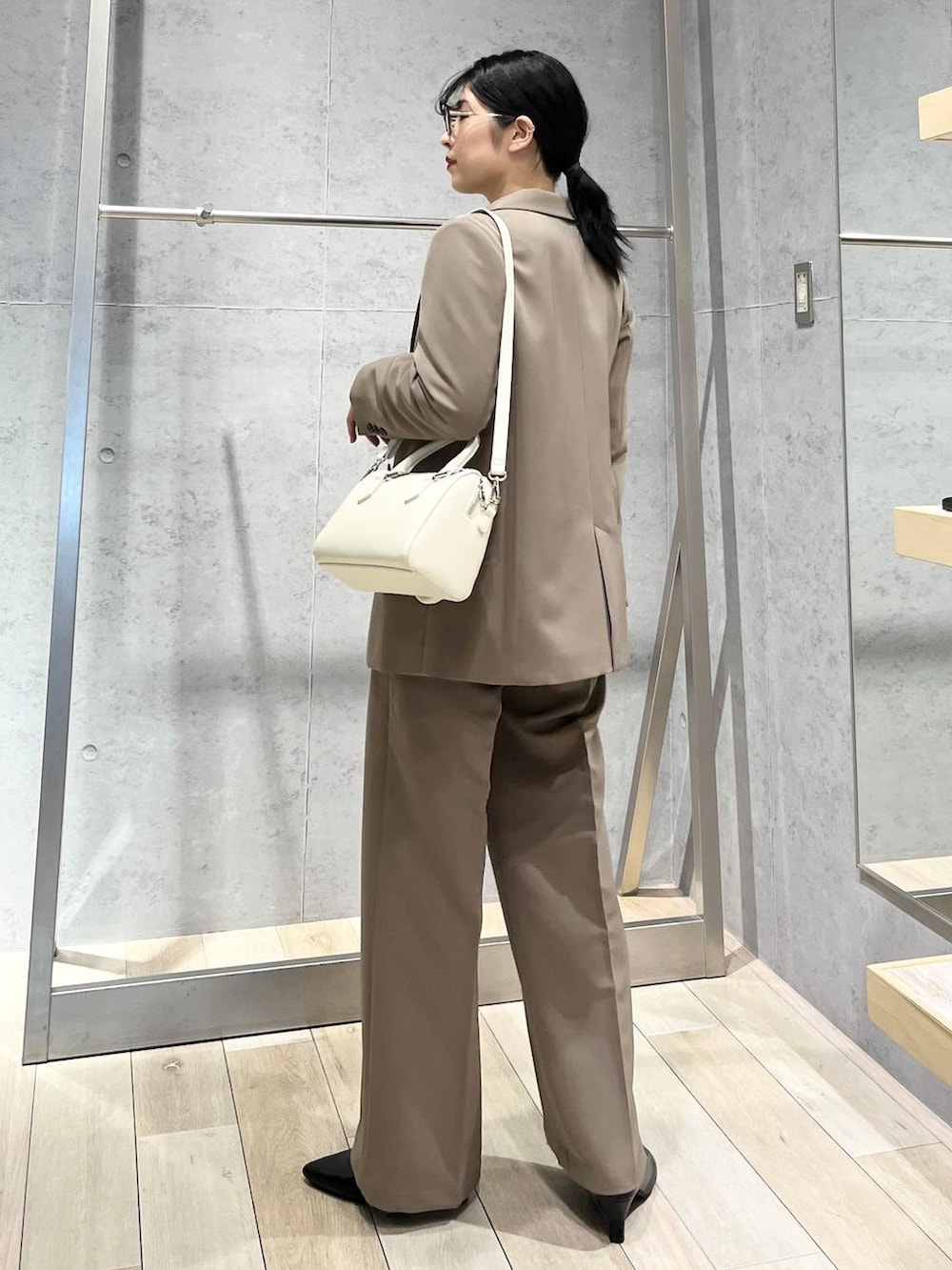 ブラック系のニット/セーター、ブラウン系のスーツパンツ、ブラック系のパンプスを着用したレディースの冬コーディネートの6枚目の写真