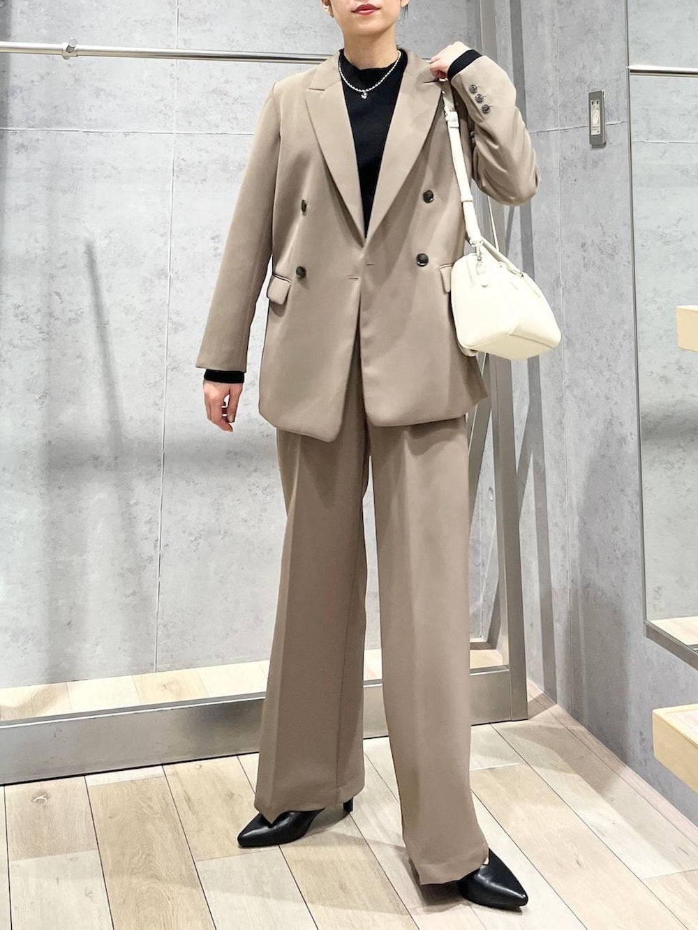 ブラック系のニット/セーター、ブラウン系のスーツパンツ、ブラック系のパンプスを着用したレディースの冬コーディネートの8枚目の写真