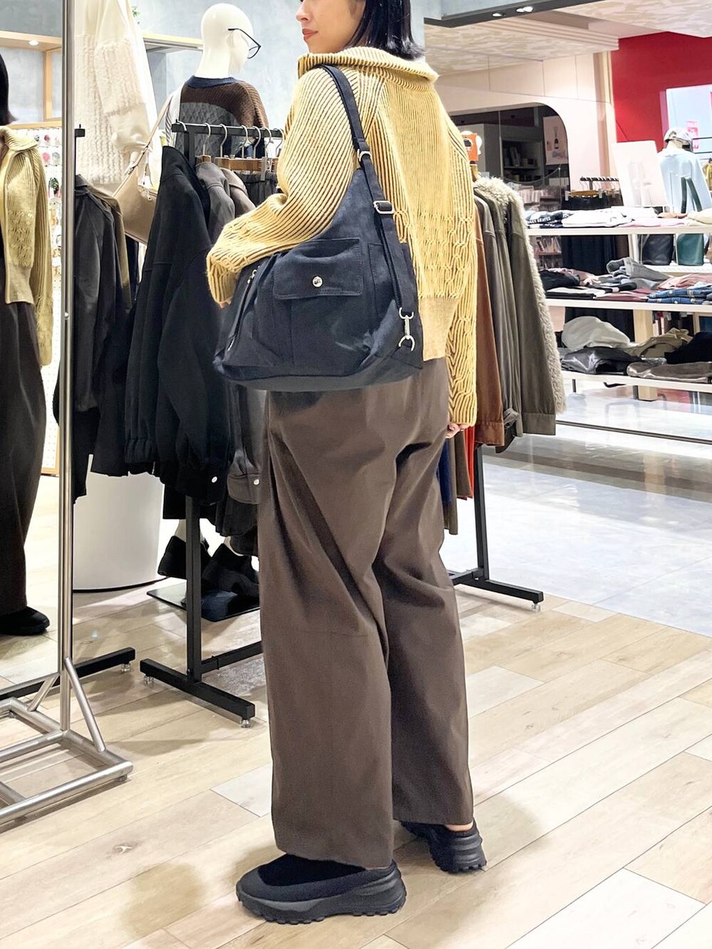ブラウン系のその他パンツ、ブラック系のその他シューズ、ブラック系のショルダーバッグを着用したレディースの冬コーディネートの3枚目の写真