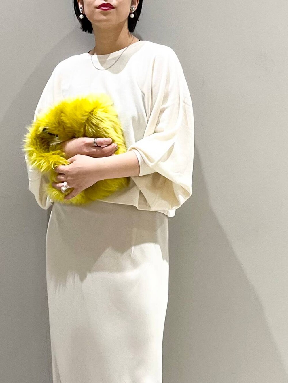 ブラック系のキャミソール、ホワイト系のニット/セーター、イエロー系のハンドバッグを着用したレディースの秋コーディネートの4枚目の写真