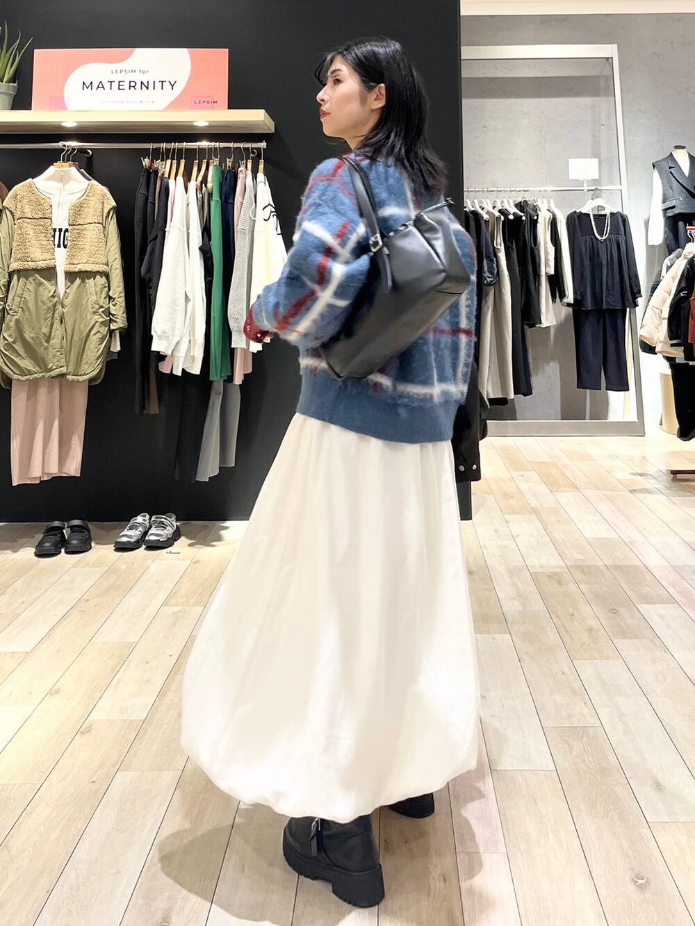 ブラック系のTシャツ/カットソー、ブラック系のブーツ、ブラック系のショルダーバッグを着用したレディースの冬コーディネートの5枚目の写真