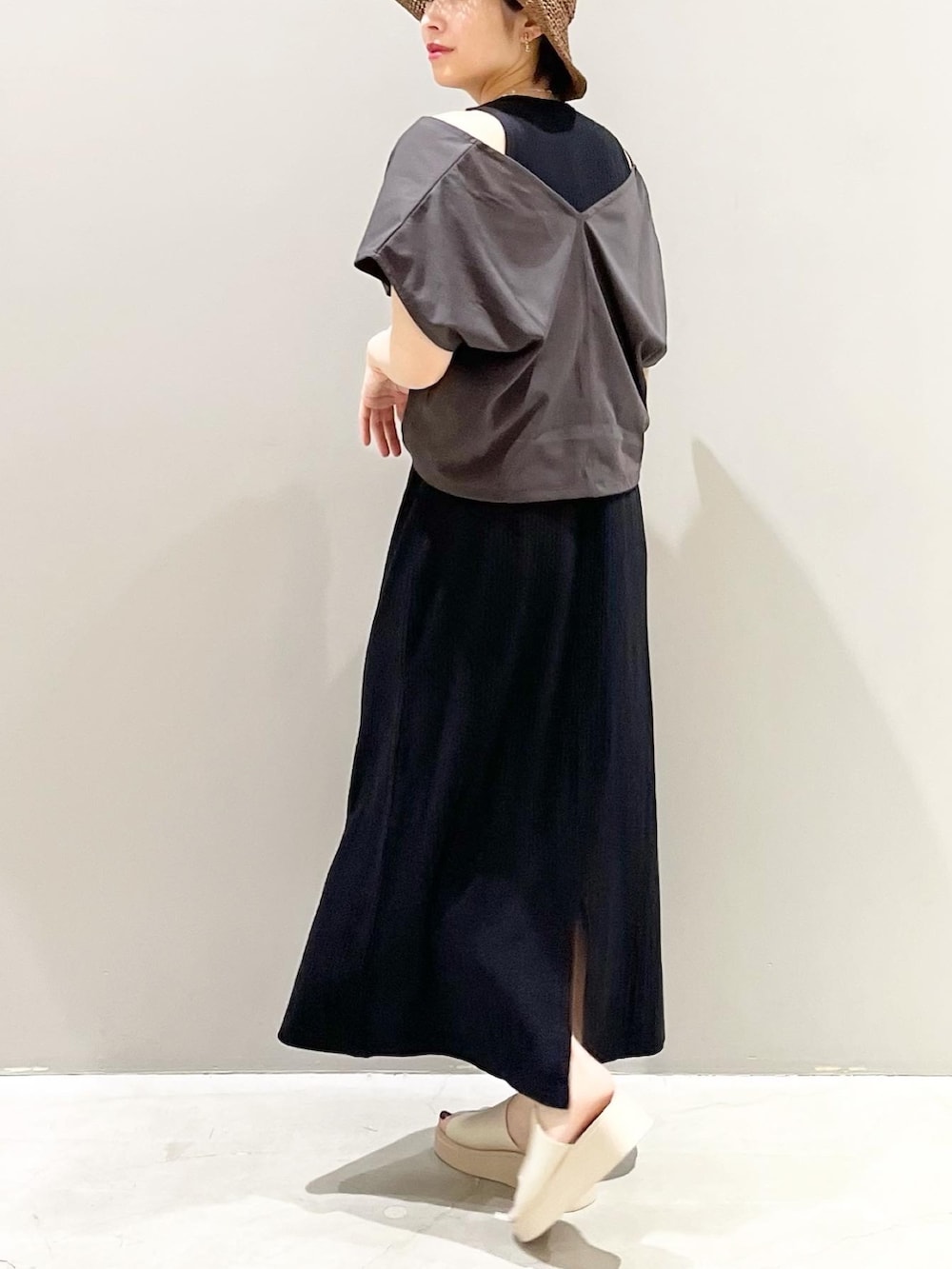 ベージュ系のサンダル、ブラック系のワンピース、ブラウン系のハットを着用したレディースの春コーディネートの3枚目の写真