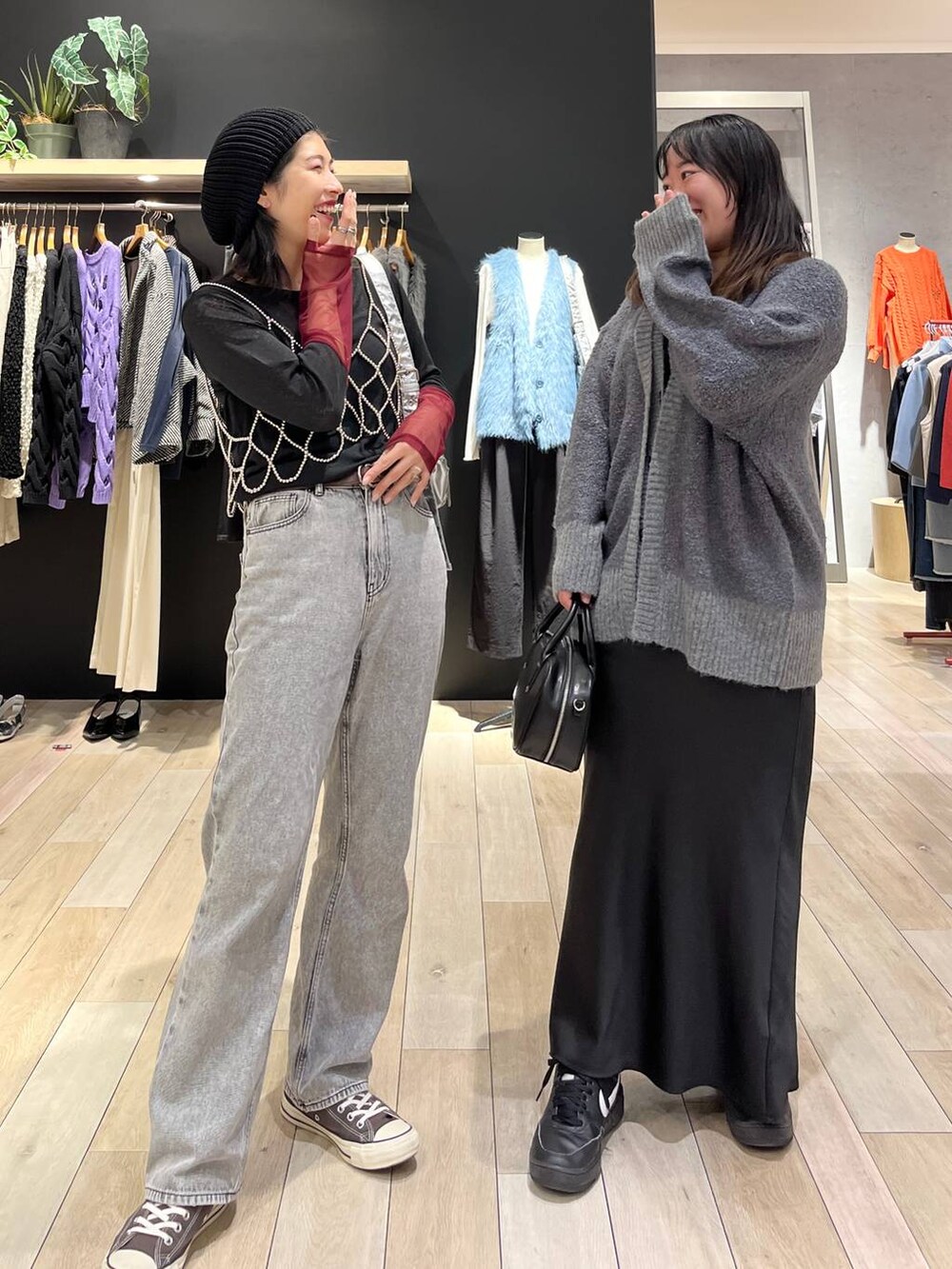 シルバー系のベスト、シルバー系のショルダーバッグ、グレー系のデニムパンツを着用したレディースの秋コーディネートの5枚目の写真