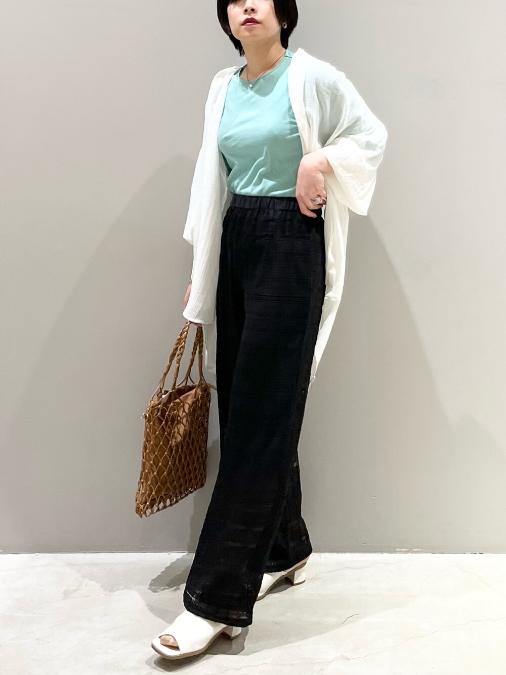 ブラック系のその他パンツ、ホワイト系のサンダル、ベージュ系のバッグを着用したレディースの春コーディネートの5枚目の写真