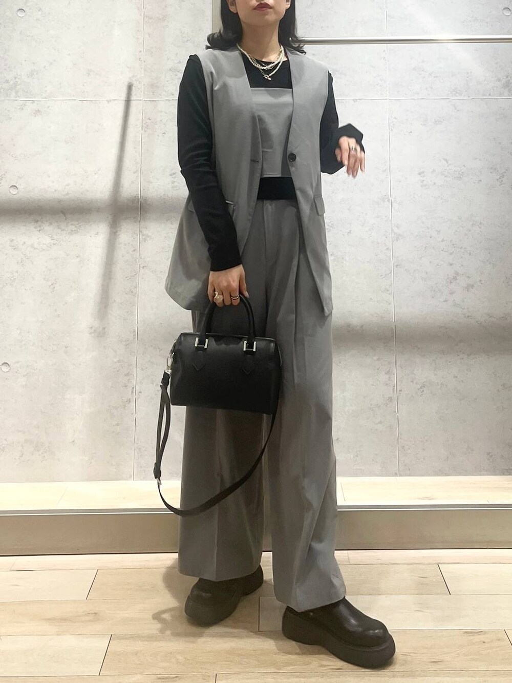 ブラック系のボストンバッグ、グレー系のその他パンツ、ブラック系のサンダルを着用したレディースの春コーディネートの5枚目の写真