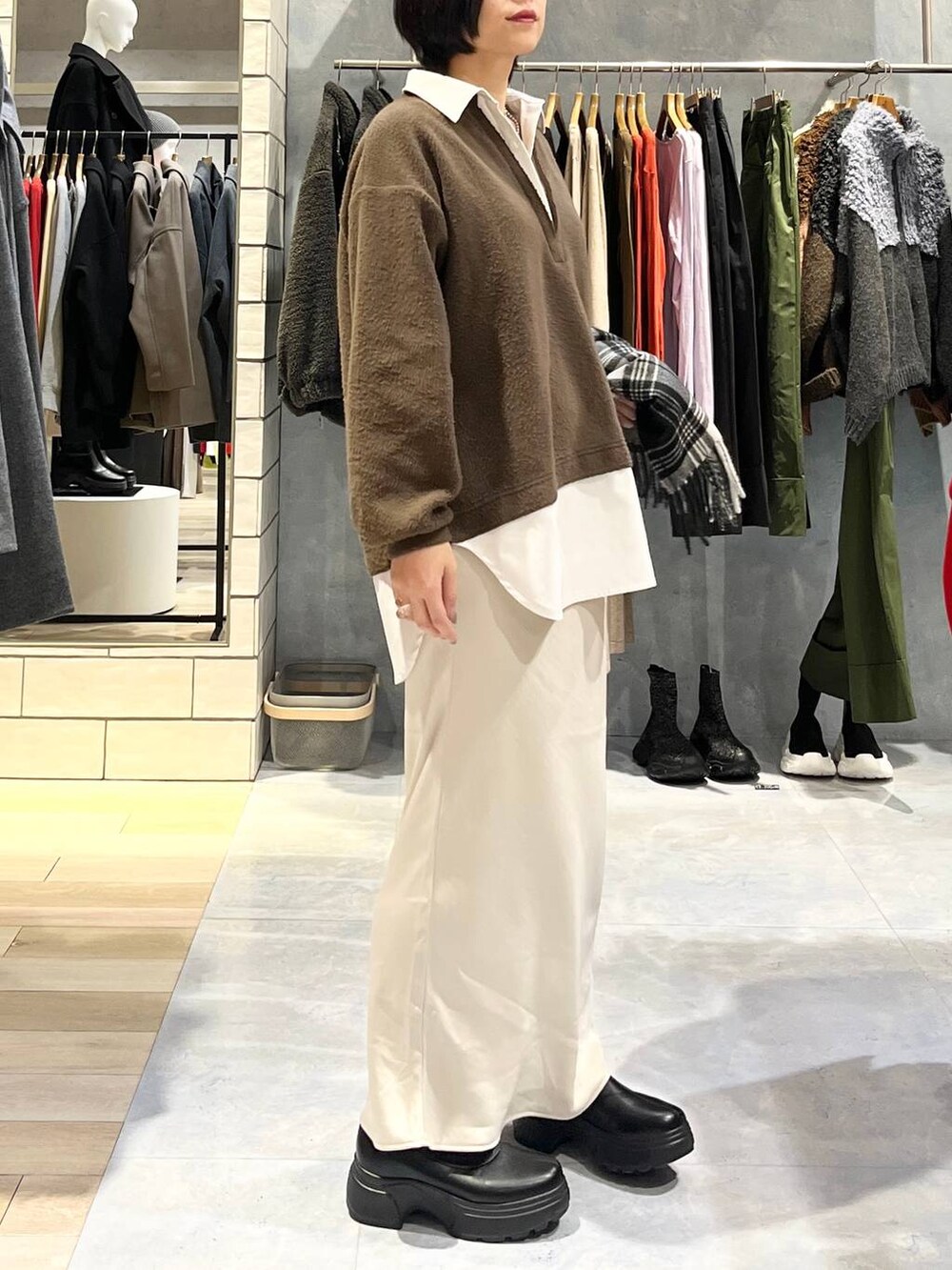 ホワイト系のスカート、ブラック系のブーツ、イエロー系のTシャツ/カットソーを着用したレディースの冬コーディネートの3枚目の写真