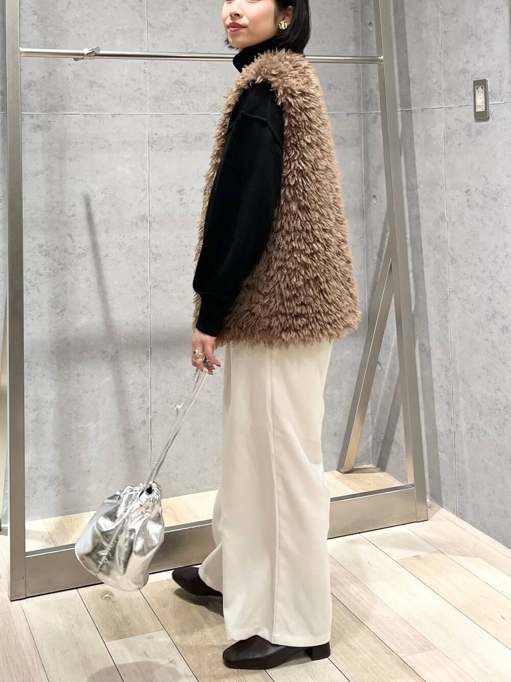 ブラック系のニット/セーター、ブラウン系のブーツ、ホワイト系のその他パンツを着用したレディースの秋コーディネートの3枚目の写真