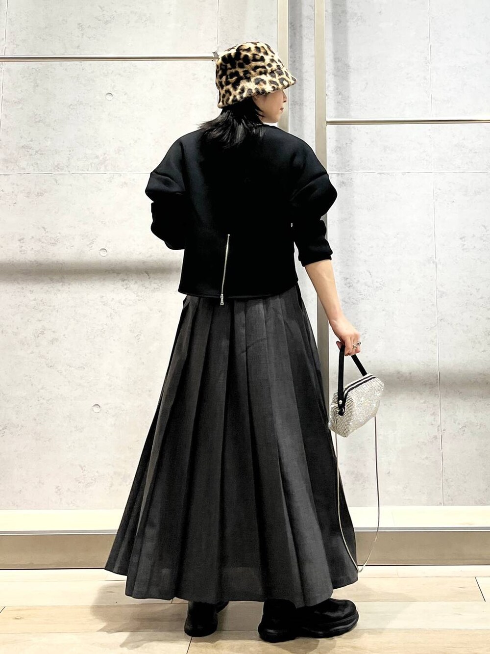 ブラック系のブーツ、ブラック系のTシャツ/カットソー、グレー系のスカートを着用したレディースの冬コーディネートの5枚目の写真