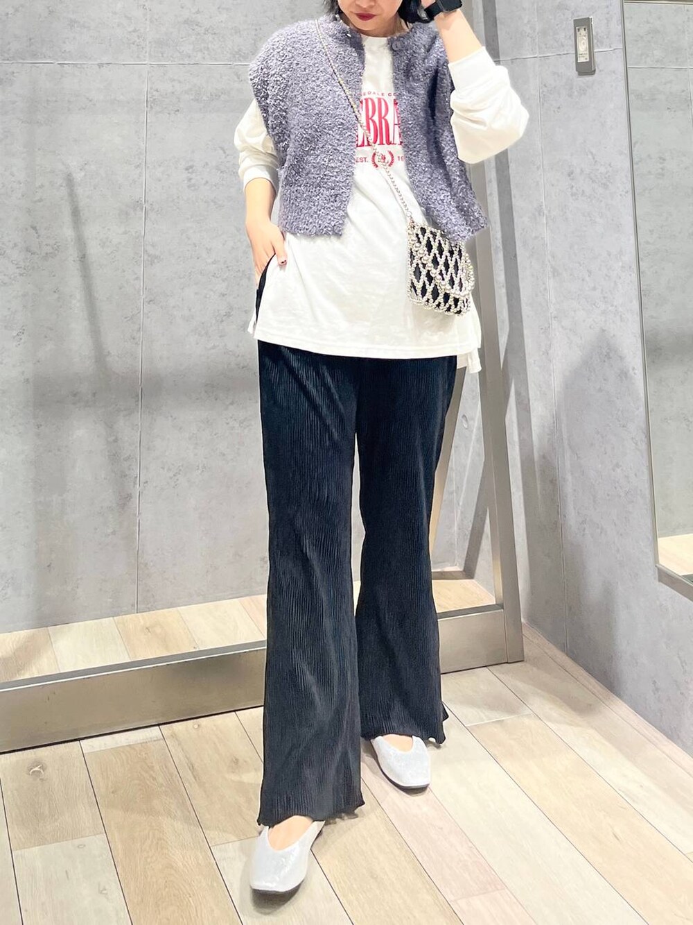 シルバー系のショルダーバッグ、ブラック系のワンピース、シルバー系のパンプスを着用したレディースの秋コーディネートの7枚目の写真