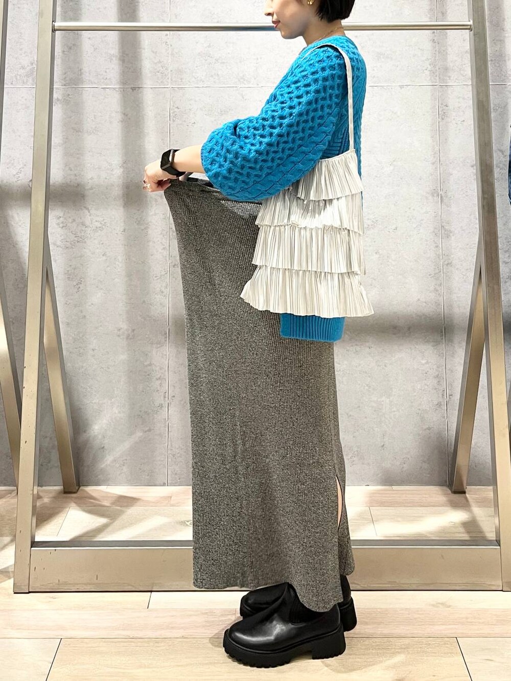 ブラック系のブーツ、シルバー系のトートバッグ、ブルー系のその他トップスを着用したレディースの秋コーディネートの2枚目の写真