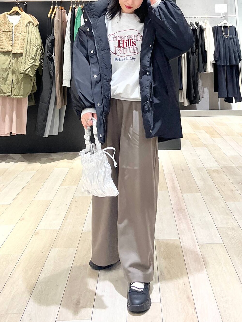 ブラック系のダウンジャケット/コート、ブラウン系のその他パンツ、グレー系のスウェットを着用したレディースの冬コーディネートの7枚目の写真