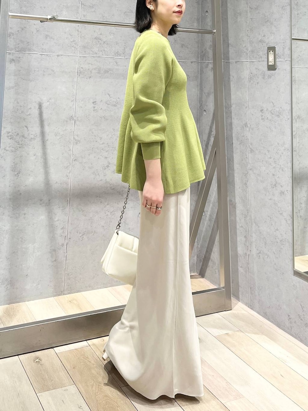 ホワイト系のショルダーバッグ、グリーン系のニット/セーター、ホワイト系のスカートを着用したレディースの春コーディネートの4枚目の写真