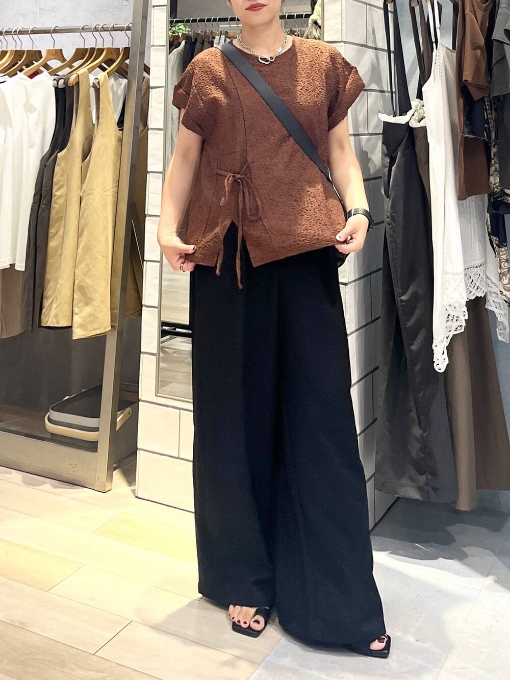 ブラック系のその他パンツ、ブラック系のショルダーバッグ、ブラック系のサンダルを着用したレディースの夏コーディネートの2枚目の写真