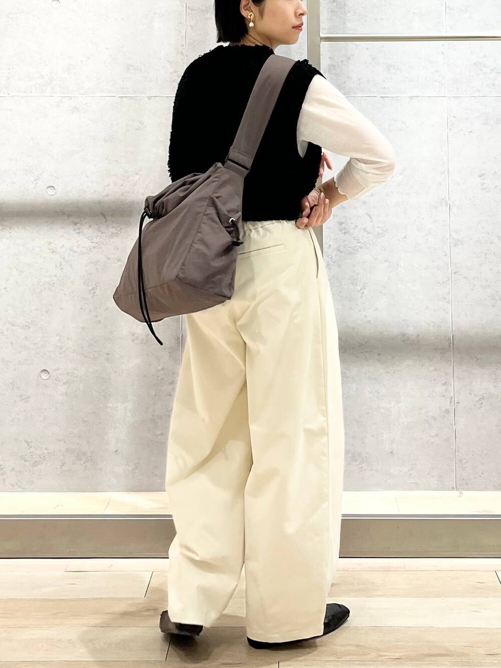 ブラック系のローファー、ホワイト系のTシャツ/カットソー、ブラック系のベストを着用したレディースの秋コーディネートの4枚目の写真