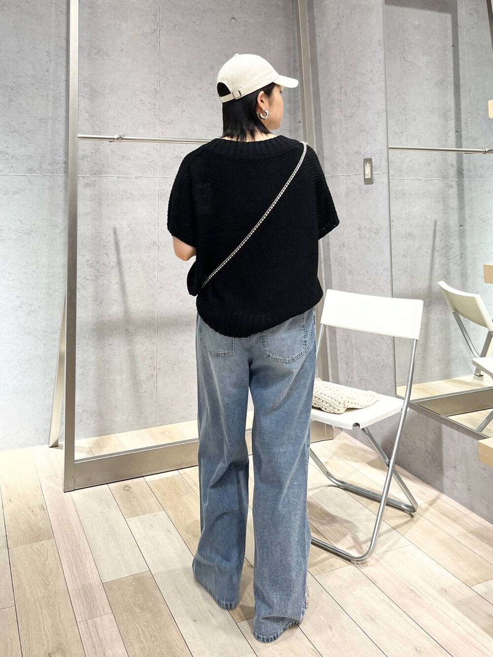 シルバー系のサンダル、ブラック系のニット/セーター、ブルー系のデニムパンツを着用したレディースの春コーディネートの8枚目の写真