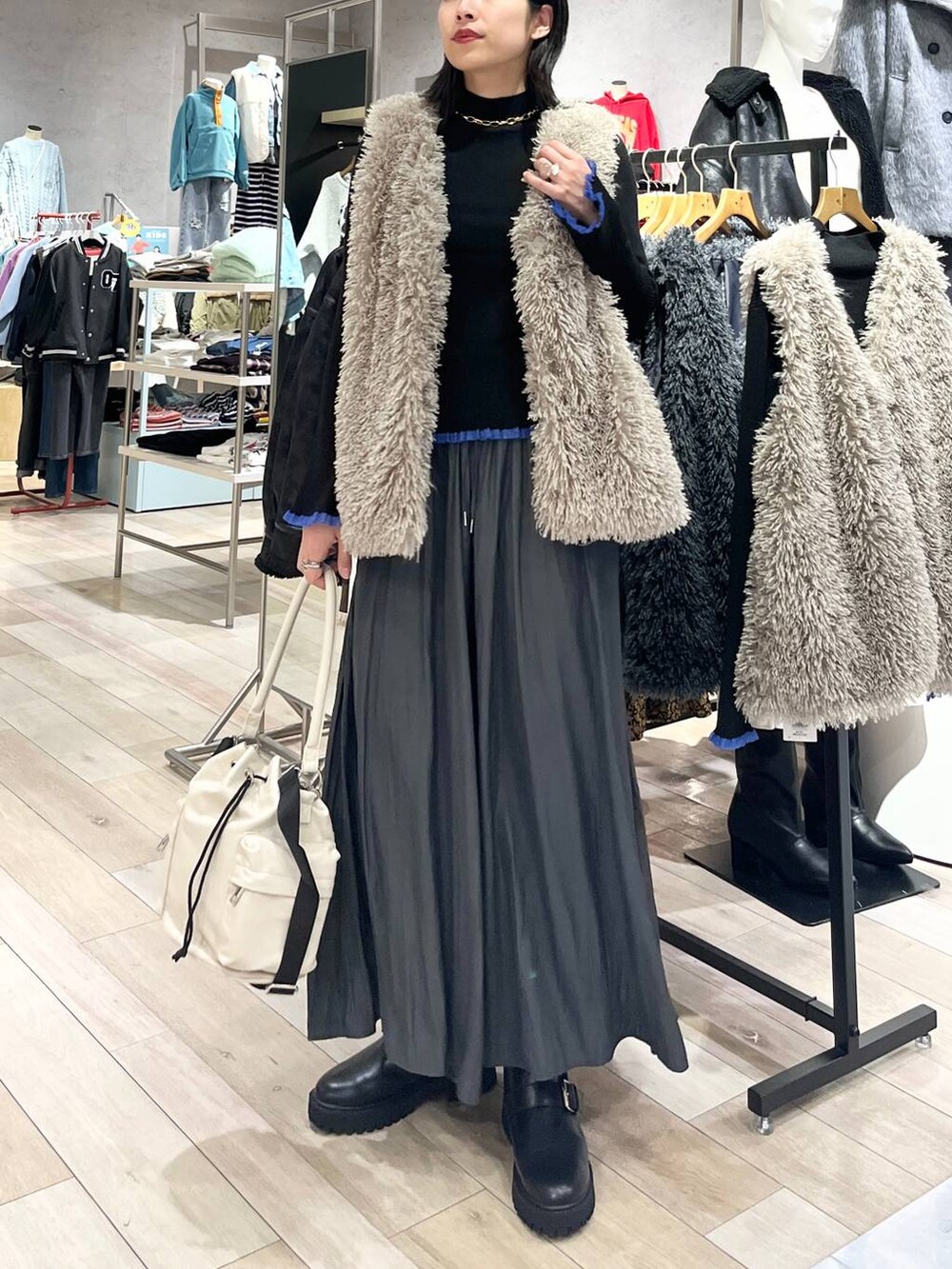 ホワイト系のショルダーバッグ、グレー系のその他パンツ、ブラック系のブーツを着用したレディースの秋コーディネートの7枚目の写真