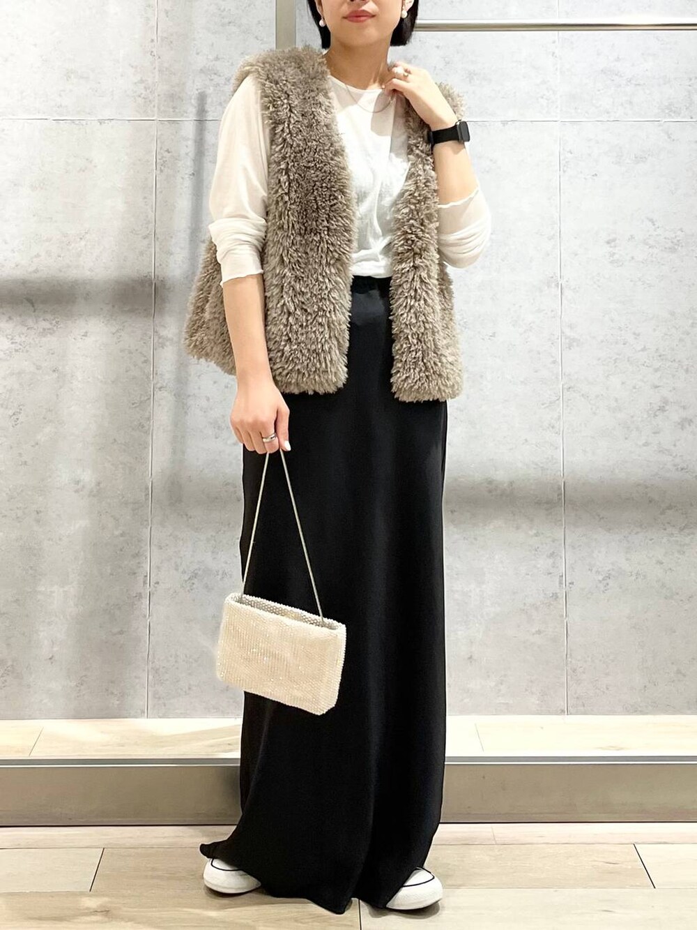 ブラック系のキャミソール、ベージュ系のベスト、ホワイト系のTシャツ/カットソーを着用したレディースの秋コーディネートの8枚目の写真