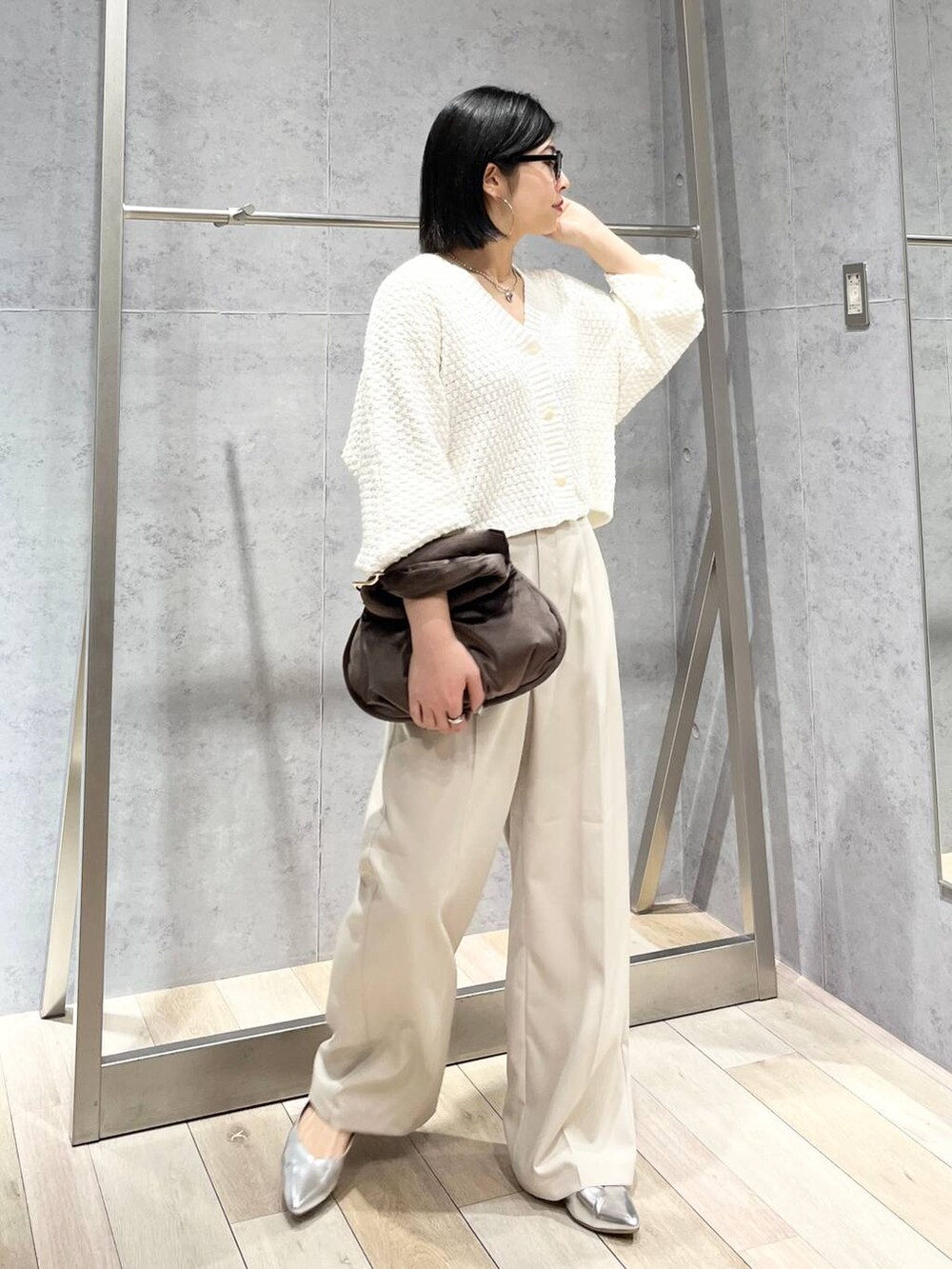 ブラウン系のハンドバッグ、グレー系のパンプス、ホワイト系のカーディガン/ボレロを着用したレディースの冬コーディネートの9枚目の写真