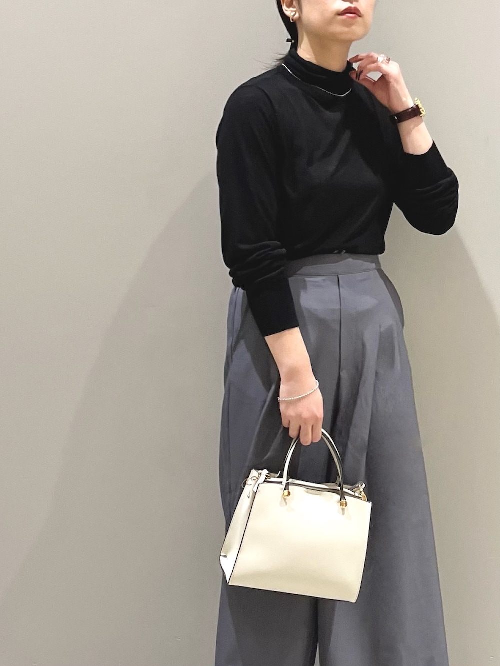 ブラック系のパンプス、ホワイト系のショルダーバッグ、ブラック系のTシャツ/カットソーを着用したレディースの秋コーディネートの2枚目の写真