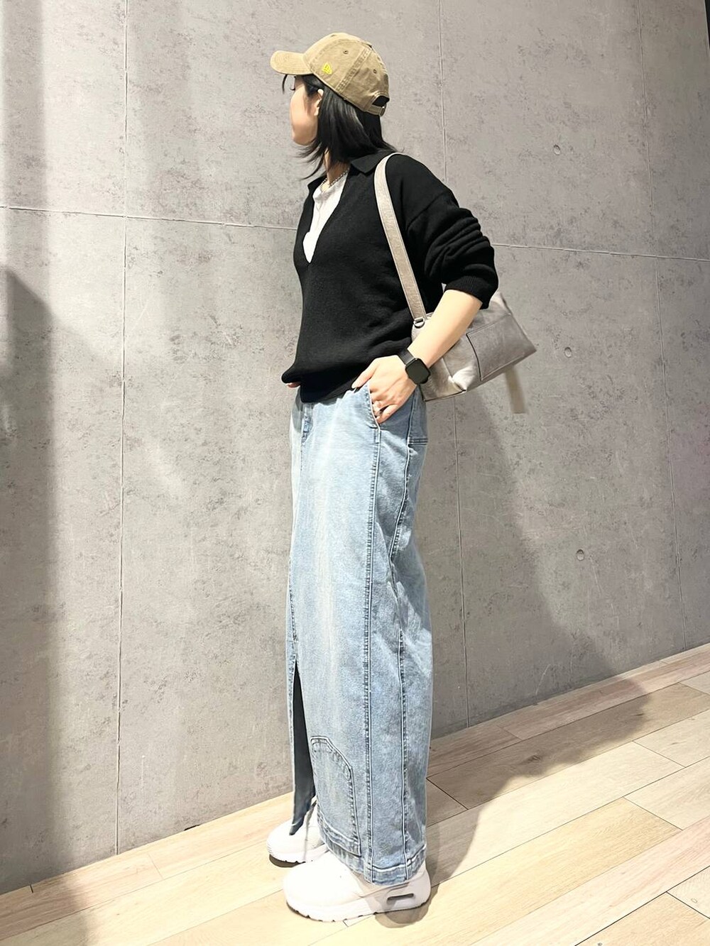 グレー系のTシャツ/カットソー、ブルー系のデニムスカート、ブラック系のニット/セーターを着用したレディースの冬コーディネートの3枚目の写真