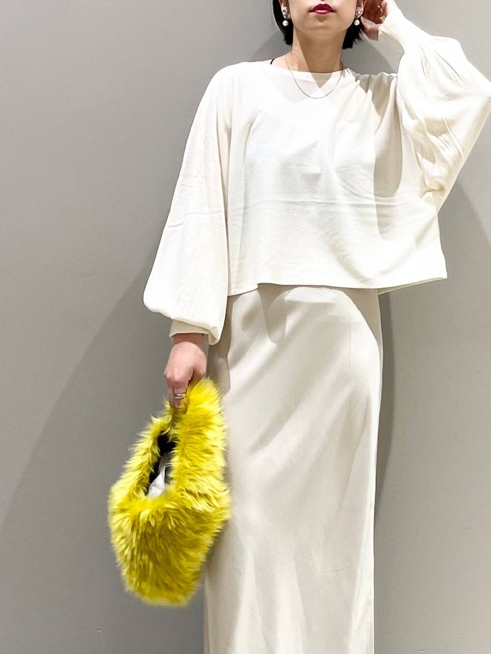 ブラック系のキャミソール、ホワイト系のニット/セーター、イエロー系のハンドバッグを着用したレディースの秋コーディネートの10枚目の写真