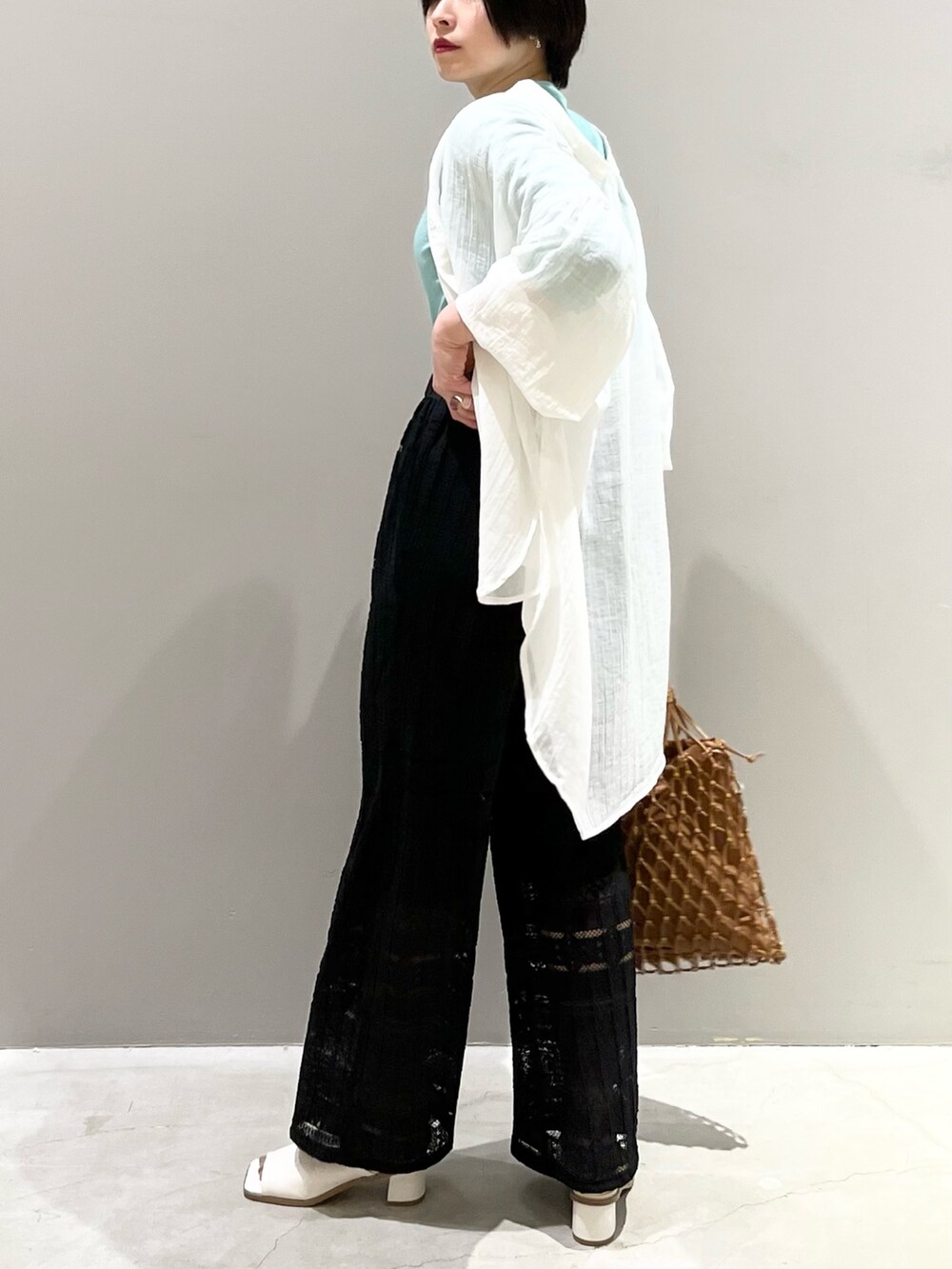 ブラック系のその他パンツ、ホワイト系のサンダル、ベージュ系のバッグを着用したレディースの春コーディネートの8枚目の写真