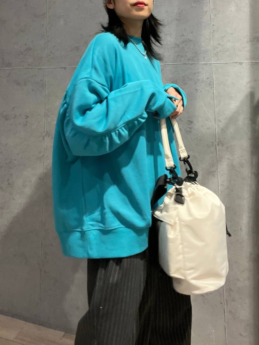 ホワイト系のショルダーバッグ、グレー系のその他パンツ、ブラック系のスニーカーを着用したレディースの冬コーディネートの5枚目の写真