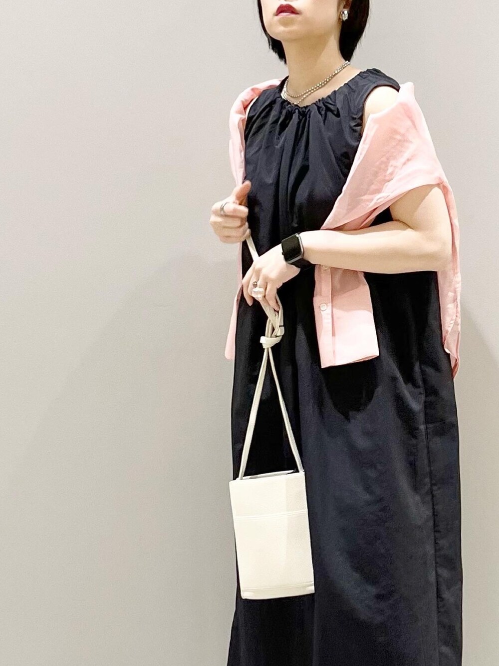 オレンジ系のバッグ、ピンク系のシャツ/ブラウス、ブラック系のワンピースを着用したレディースの夏コーディネートの5枚目の写真