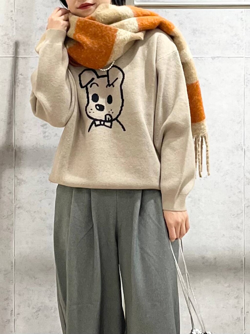 ブラック系のモカシン/デッキシューズ、グレー系のその他パンツ、ベージュ系のニット/セーターを着用したレディースの秋コーディネートの2枚目の写真