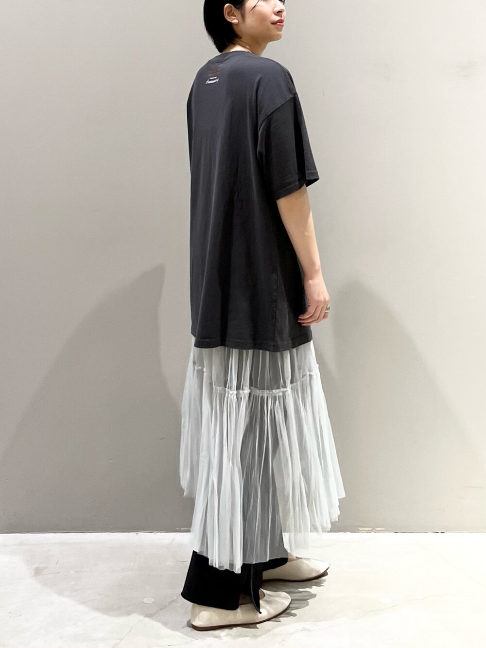 ブラック系のデニムパンツ、グレー系のスカート、ゴールド系のハンドバッグを着用したレディースの夏コーディネートの6枚目の写真