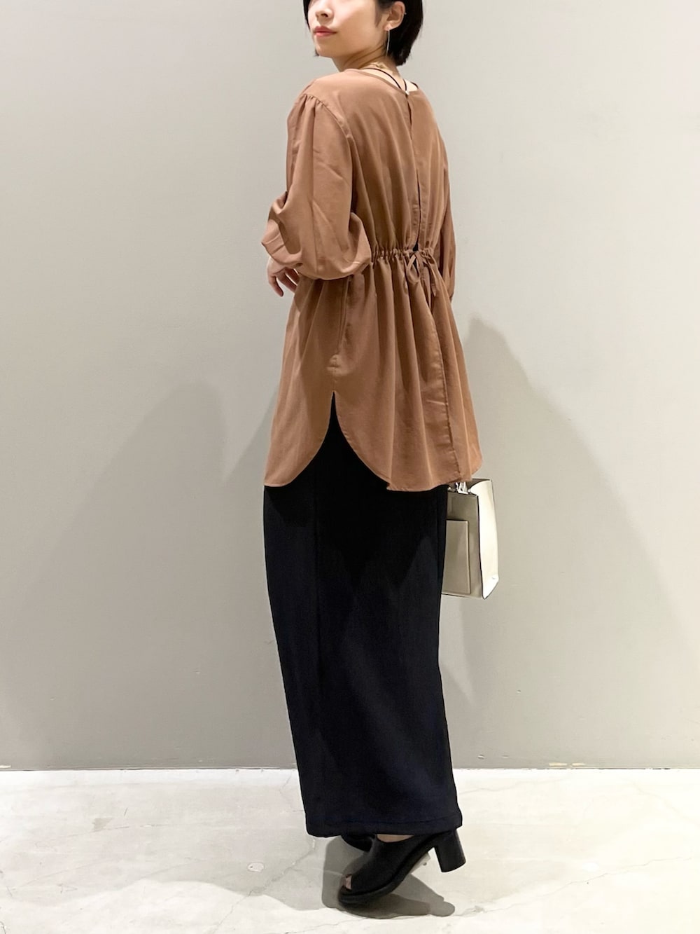 イエロー系のシャツ/ブラウス、ブラック系のスカート、ブラウン系のバッグを着用したレディースの秋コーディネートの5枚目の写真