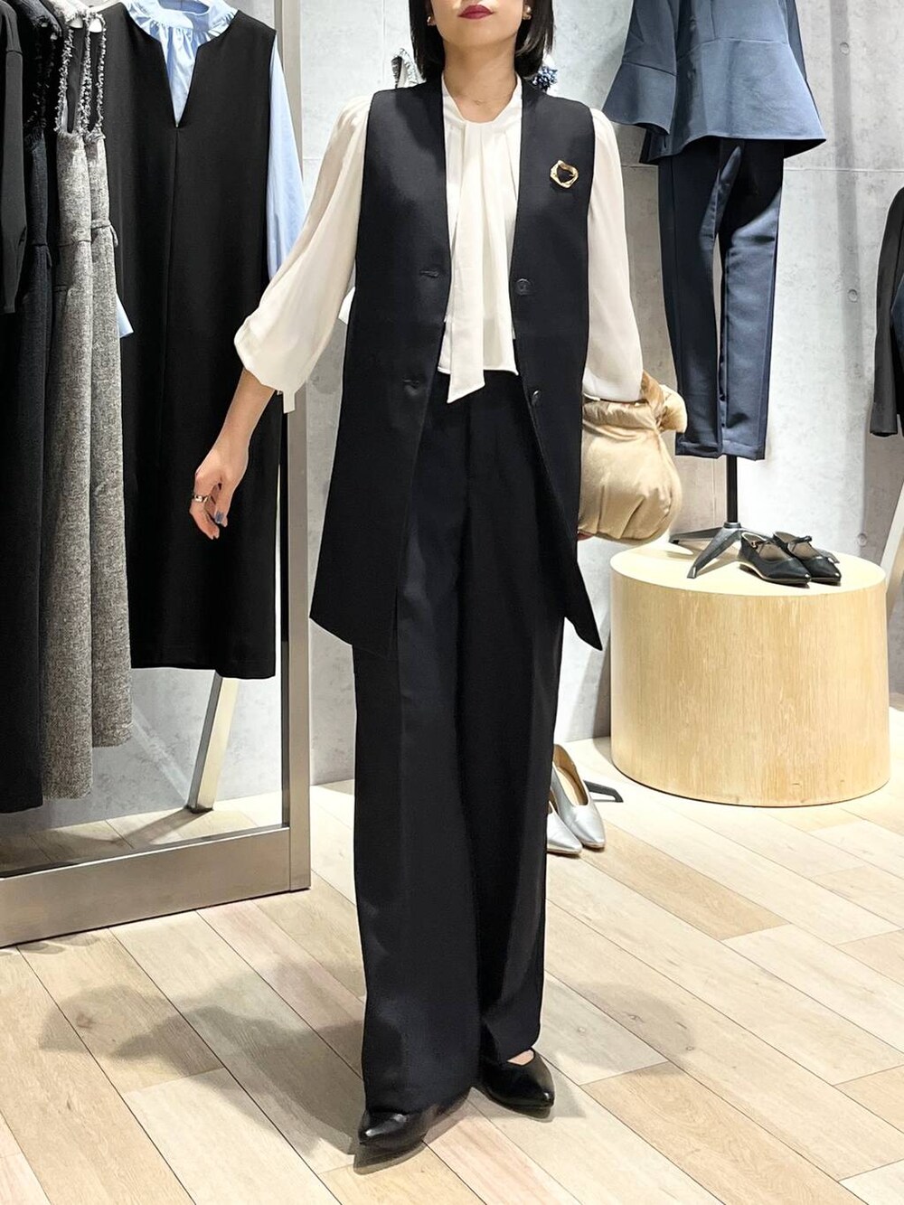 ベージュ系のハンドバッグ、ホワイト系のシャツ/ブラウス、ブラック系のパンプスを着用したレディースの冬コーディネートの6枚目の写真