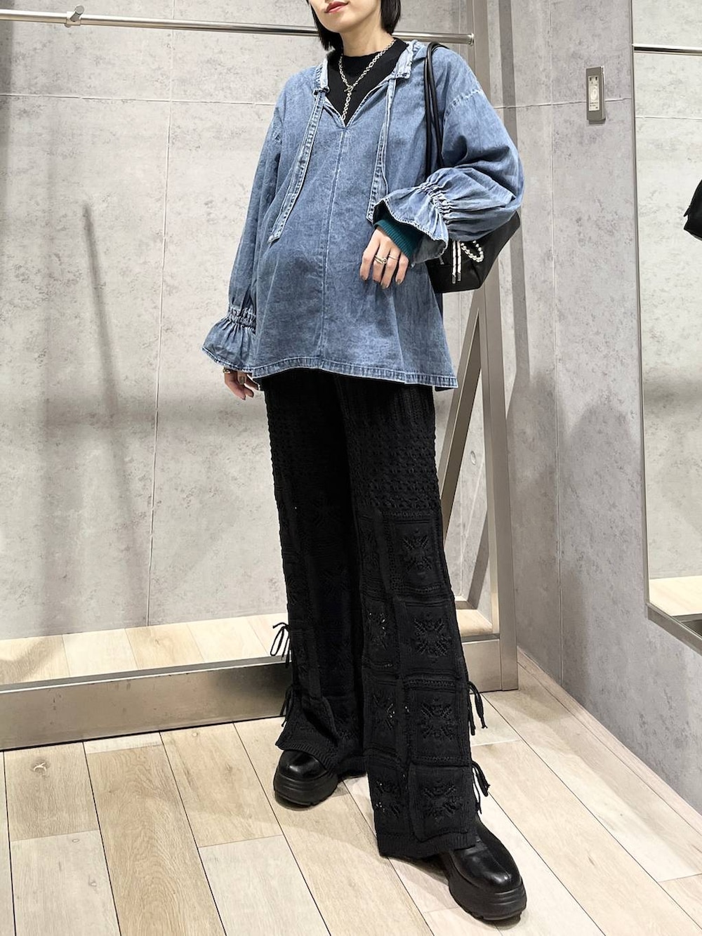 ブラック系のブーツ、ブラック系のボストンバッグ、ブラック系のその他パンツを着用したレディースの冬コーディネートの2枚目の写真