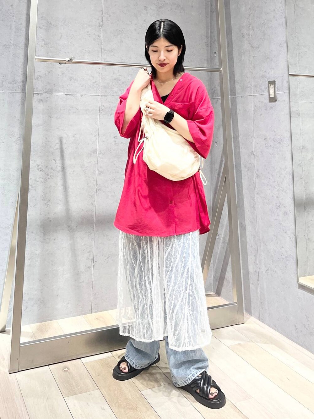 ブラック系のサンダル、ブルー系のデニムパンツ、ホワイト系のスカートを着用したレディースの夏コーディネートの2枚目の写真