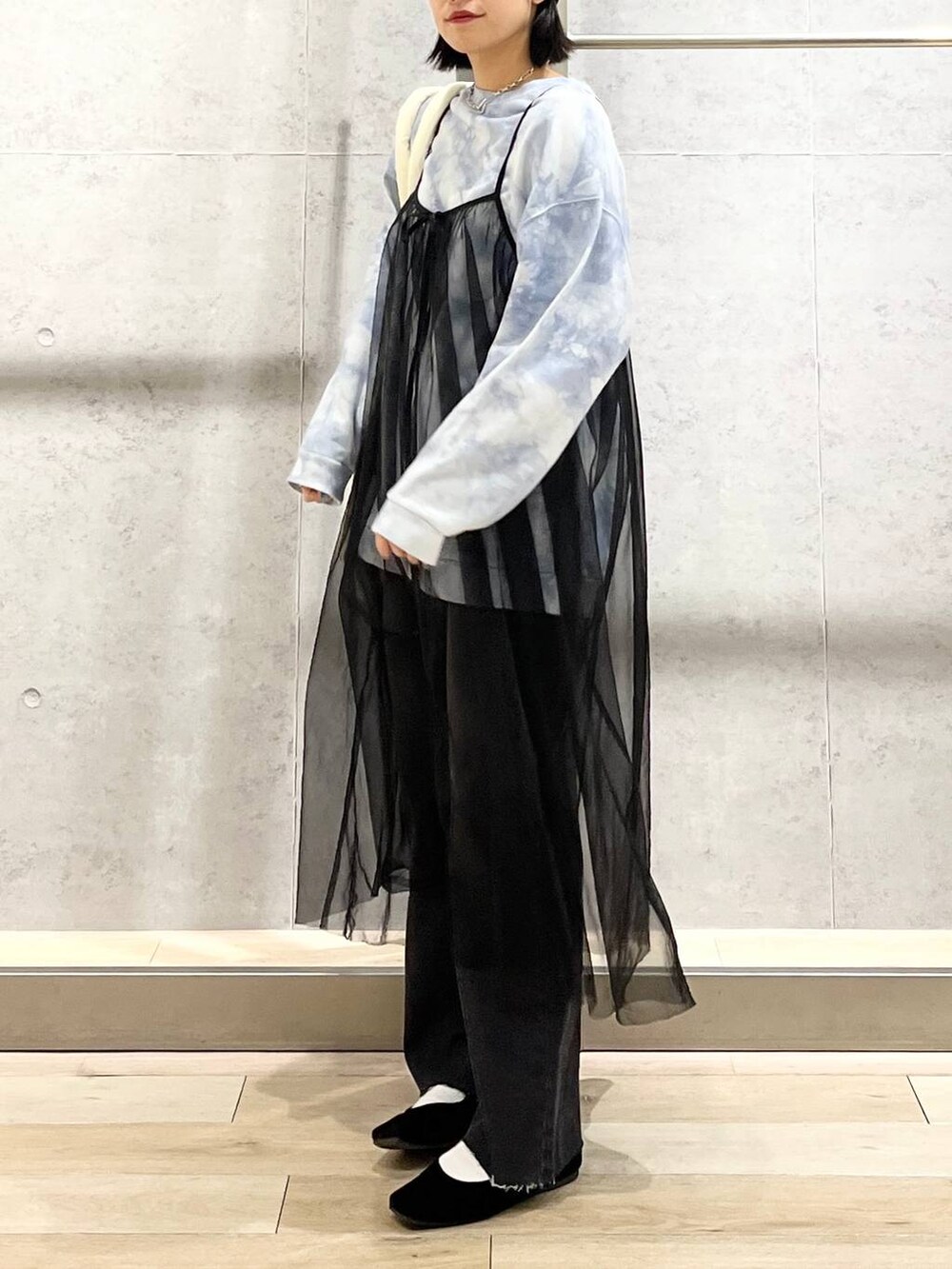 ブラック系のバレエシューズ、ホワイト系のトートバッグ、グレー系のデニムパンツを着用したレディースの冬コーディネートの5枚目の写真