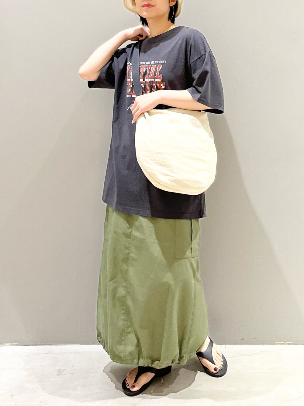 グレー系のTシャツ/カットソー、ホワイト系のショルダーバッグ、グリーン系のスカートを着用したレディースの夏コーディネートの8枚目の写真