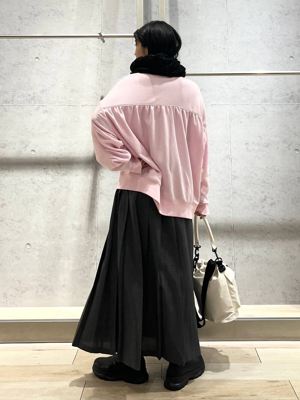 ホワイト系のショルダーバッグ、ピンク系のスウェット、ブラック系のブーツを着用したレディースの秋コーディネートの4枚目の写真