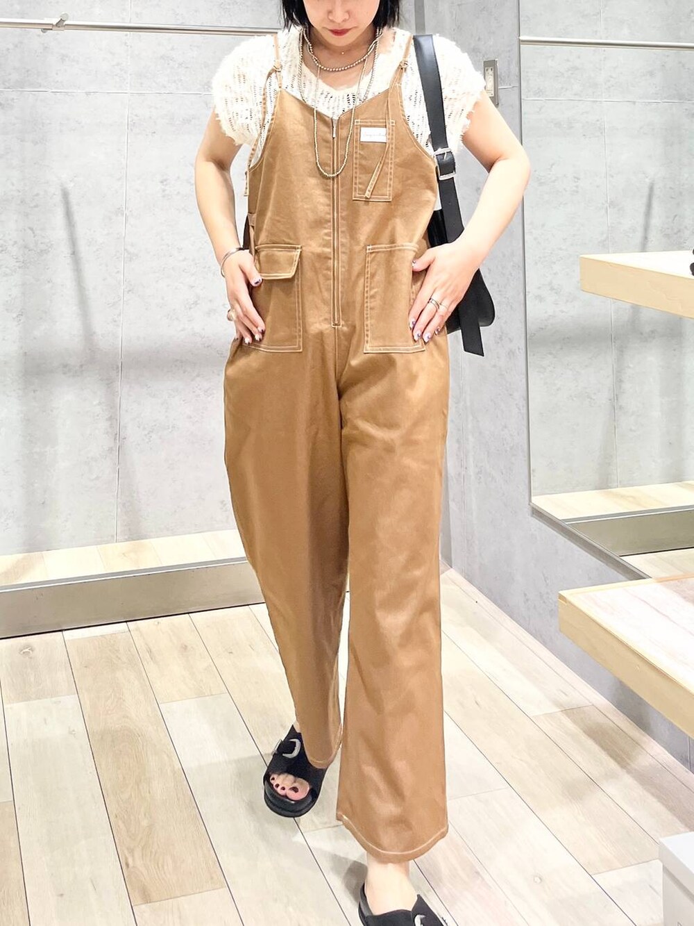 ブラック系のサンダル、ホワイト系のその他トップス、ブラック系のショルダーバッグを着用したレディースの夏コーディネートの2枚目の写真