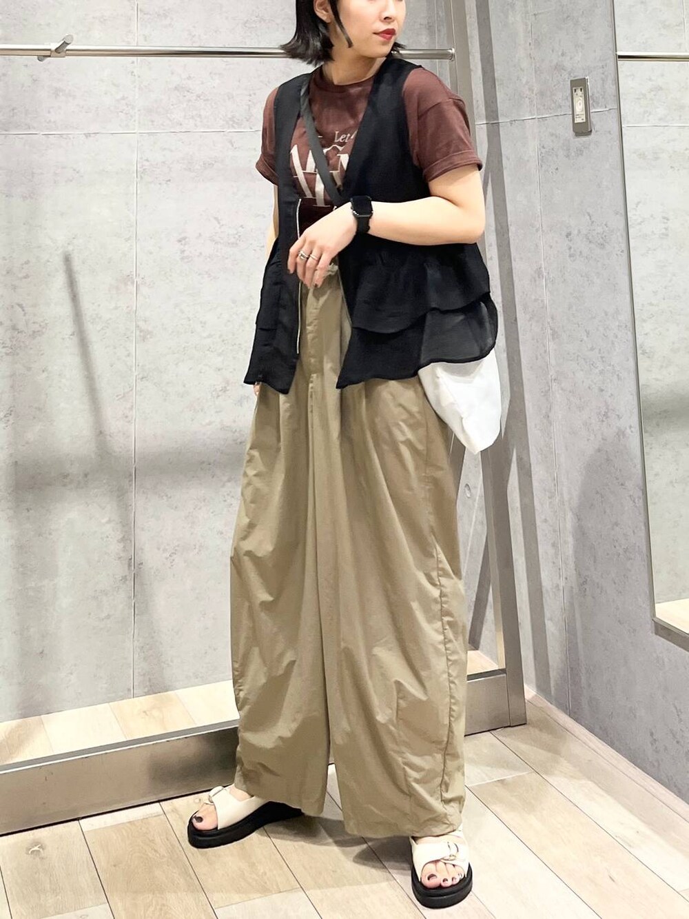 ホワイト系のサンダル、ブラック系のベスト、ブラウン系のTシャツ/カットソーを着用したレディースの夏コーディネートの5枚目の写真