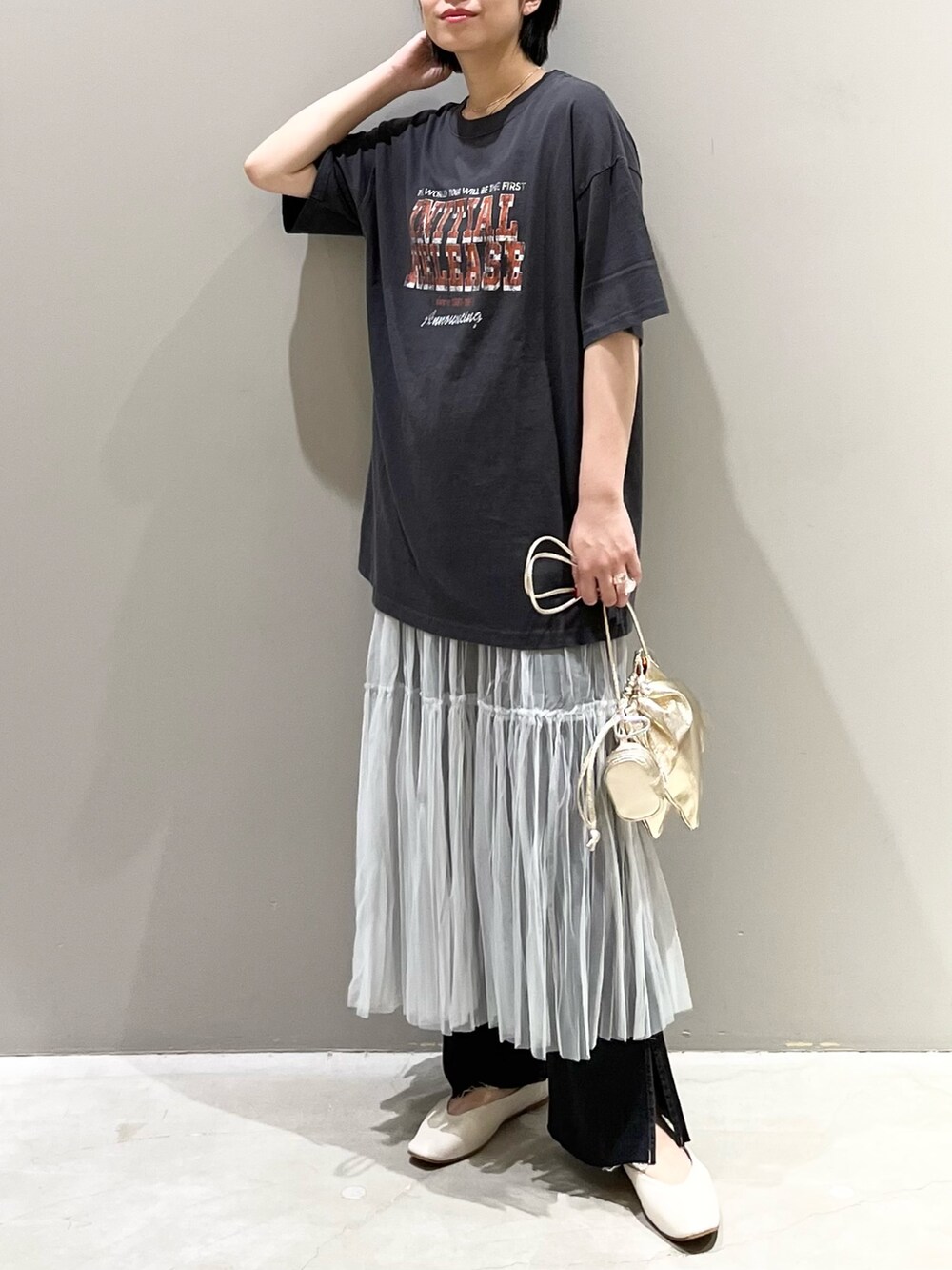 ブラック系のデニムパンツ、グレー系のスカート、ゴールド系のハンドバッグを着用したレディースの夏コーディネートの8枚目の写真