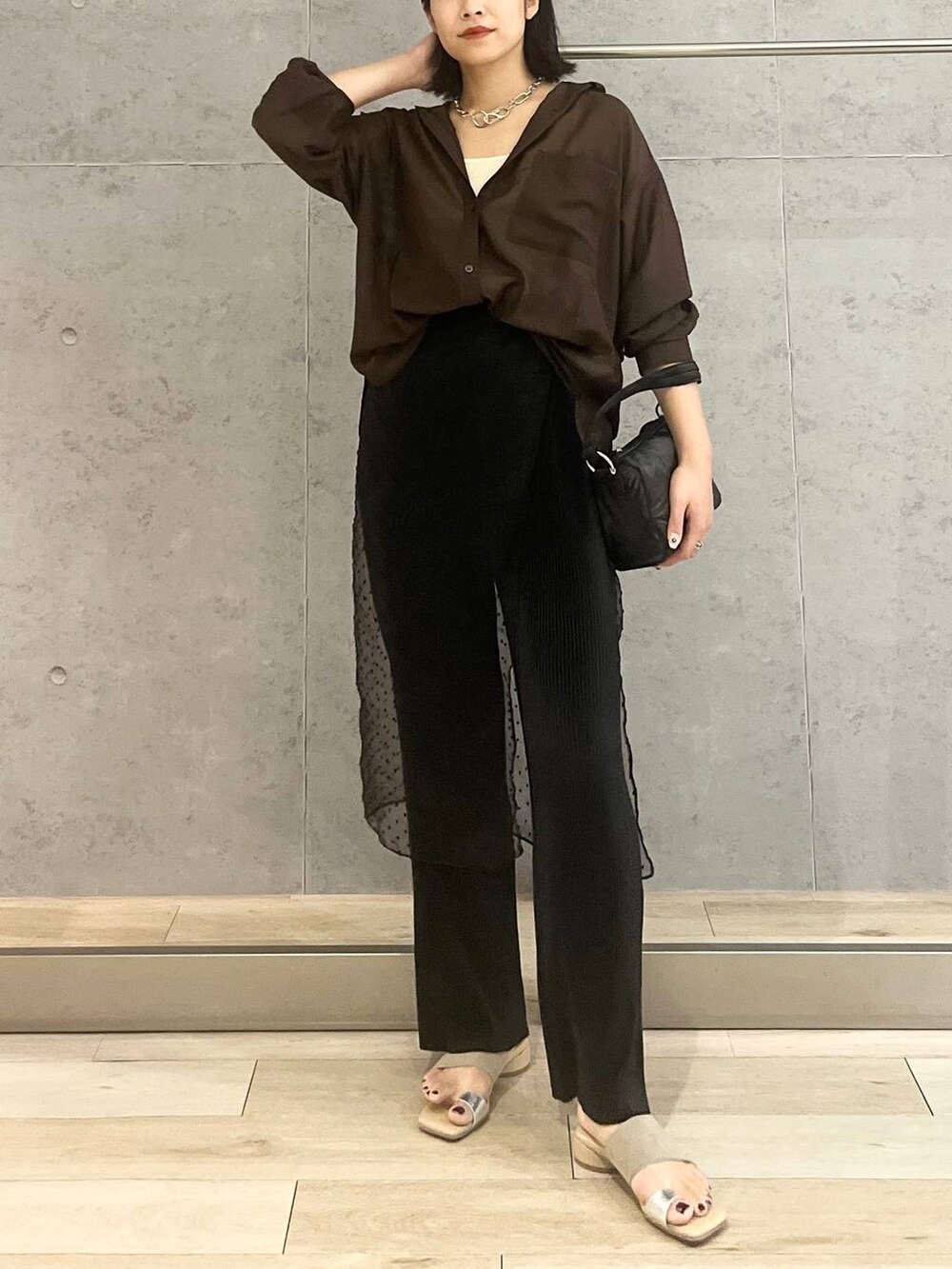 ホワイト系のタンクトップ、ブラック系のハンドバッグ、ブラック系のその他パンツを着用したレディースの夏コーディネートの6枚目の写真