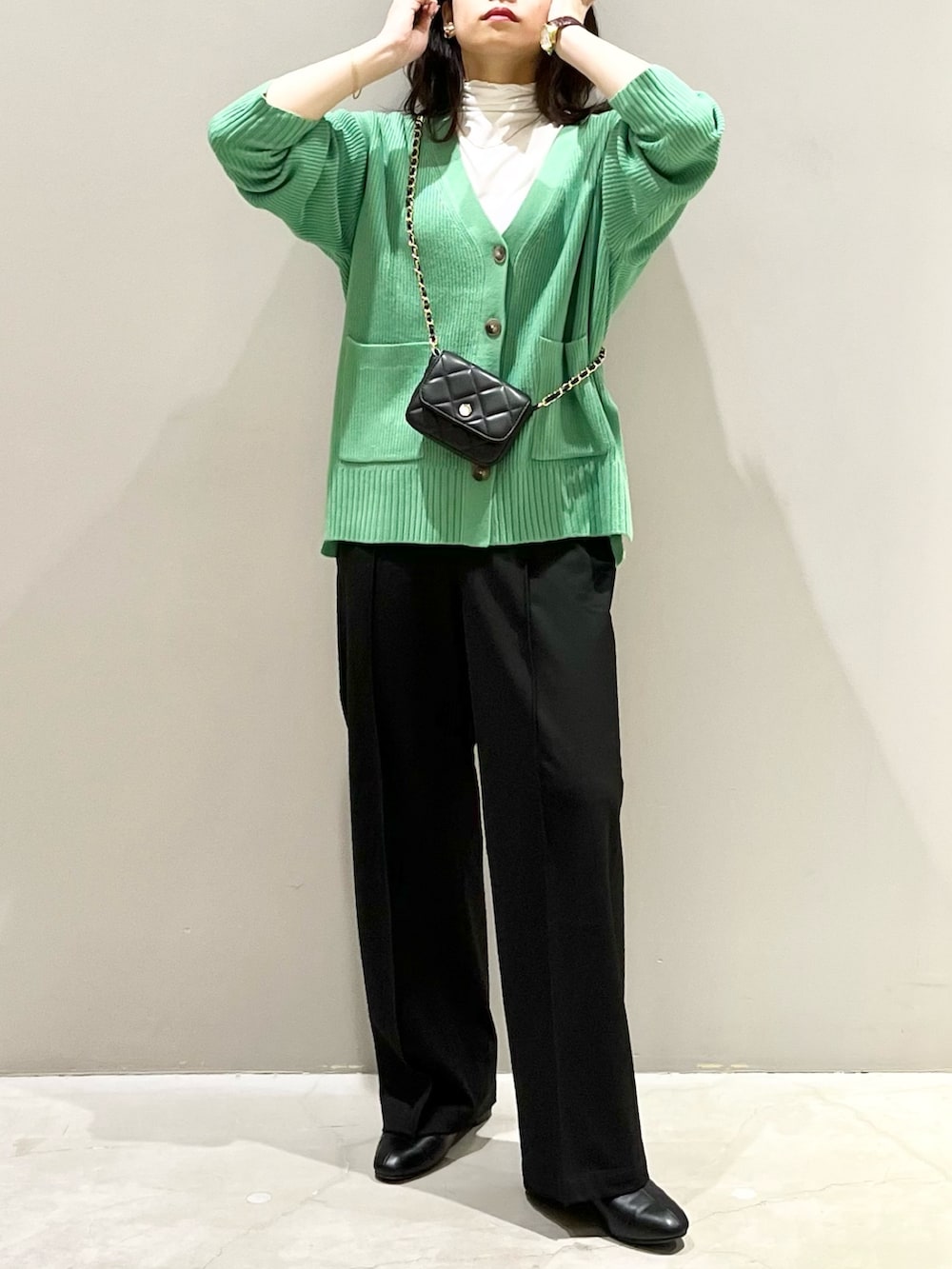 ブラック系のブーツ、ブラック系のスラックス、ブラック系のショルダーバッグを着用したレディースの秋コーディネートの5枚目の写真