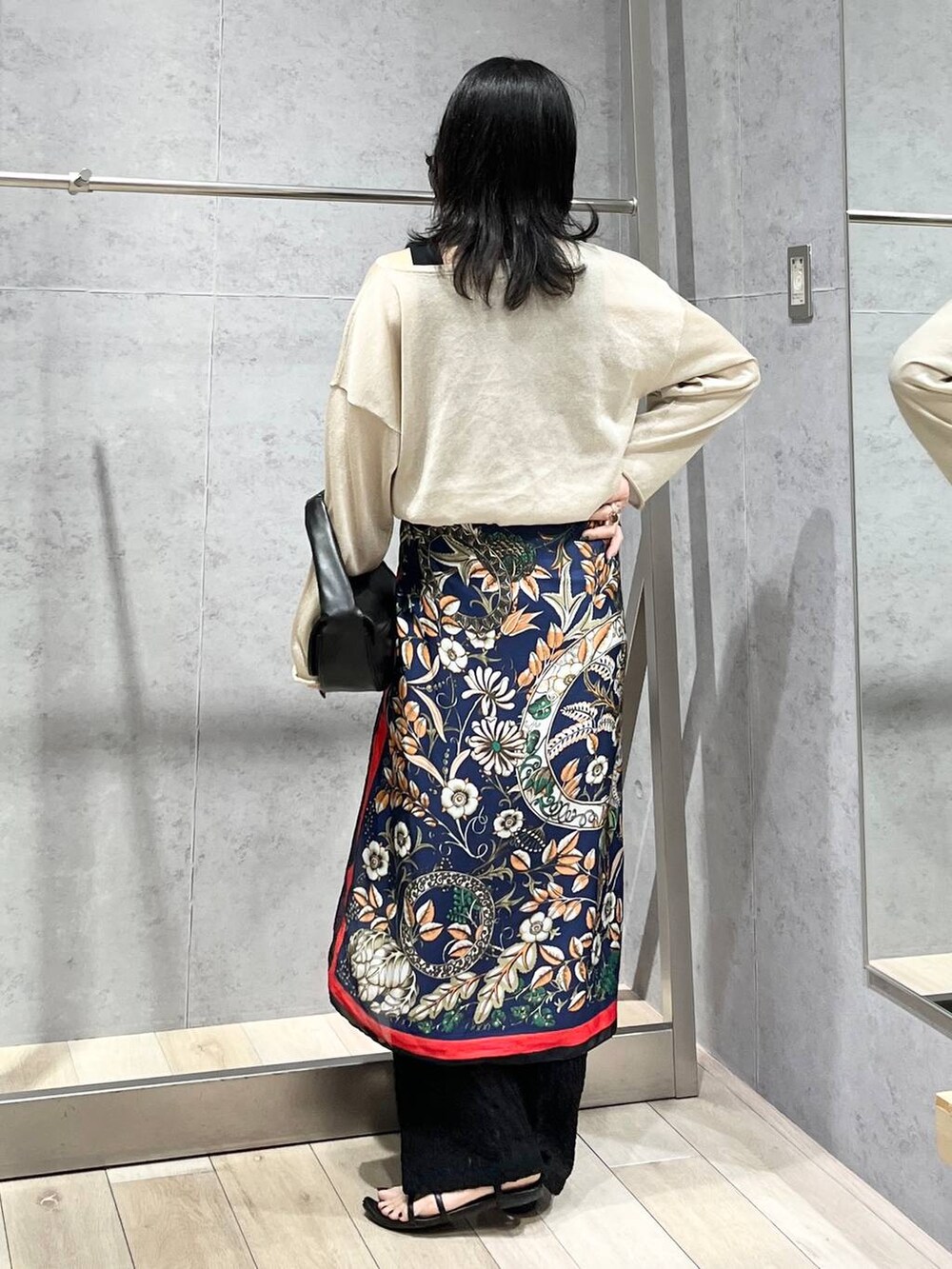 ブラック系のハンドバッグ、ベージュ系のニット/セーター、ブラック系のその他パンツを着用したレディースの春コーディネートの4枚目の写真