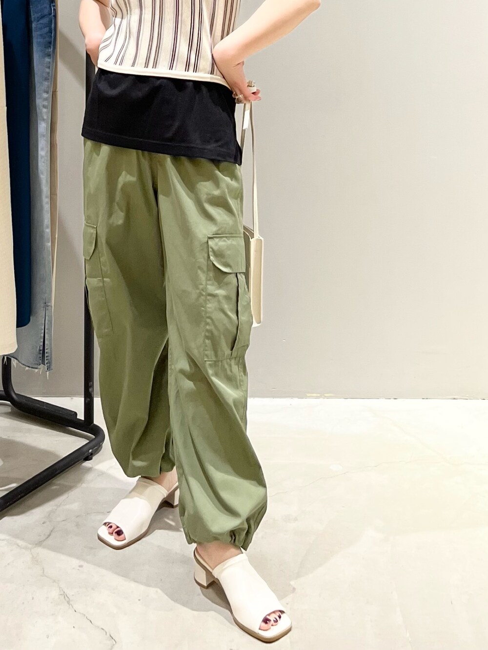 ベージュ系のタンクトップ、ブラック系のTシャツ/カットソー、グリーン系のパンツを着用したレディースの夏コーディネートの5枚目の写真