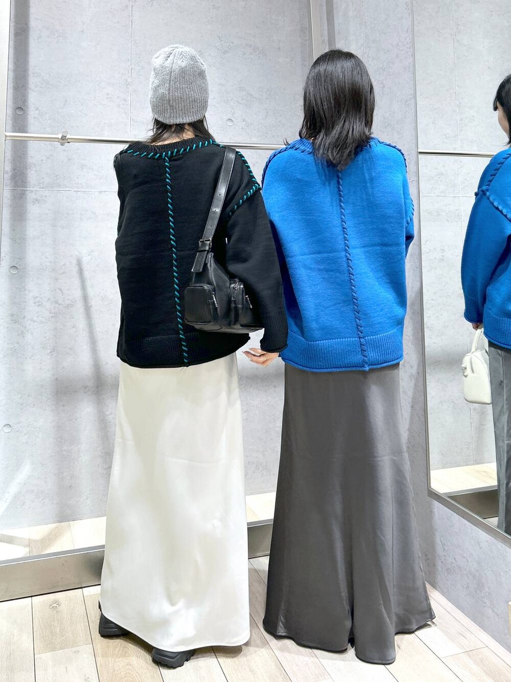 グレー系のスカート、ブラック系のパンプス、ホワイト系のボストンバッグを着用したレディースの冬コーディネートの3枚目の写真