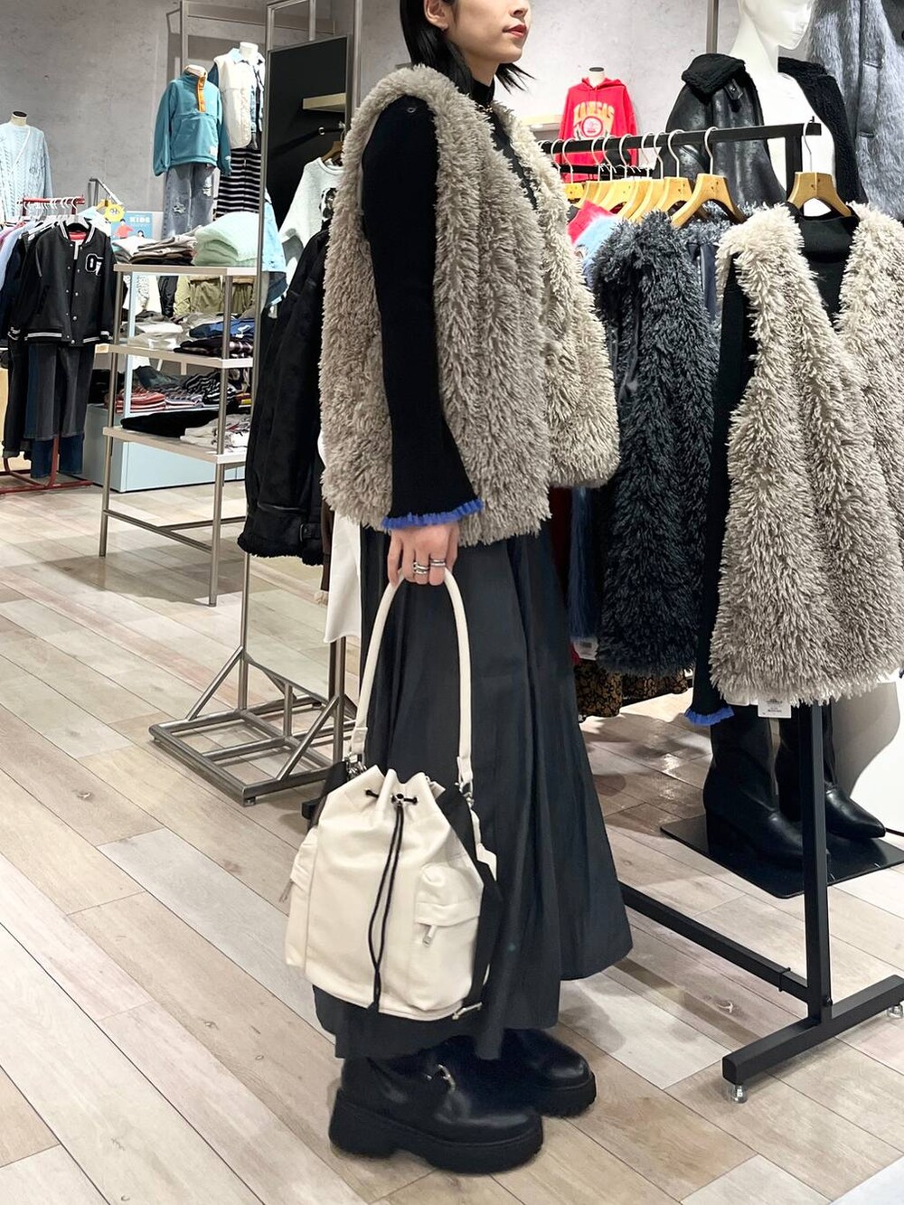 ホワイト系のショルダーバッグ、グレー系のその他パンツ、ブラック系のブーツを着用したレディースの秋コーディネートの5枚目の写真