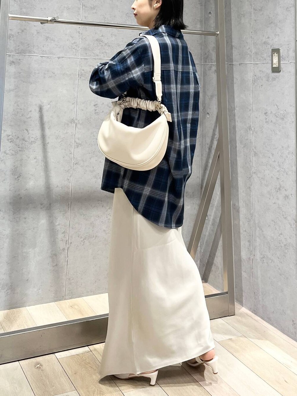 ホワイト系のショルダーバッグ、ホワイト系のスカート、ブルー系のシャツ/ブラウスを着用したレディースの冬コーディネートの4枚目の写真
