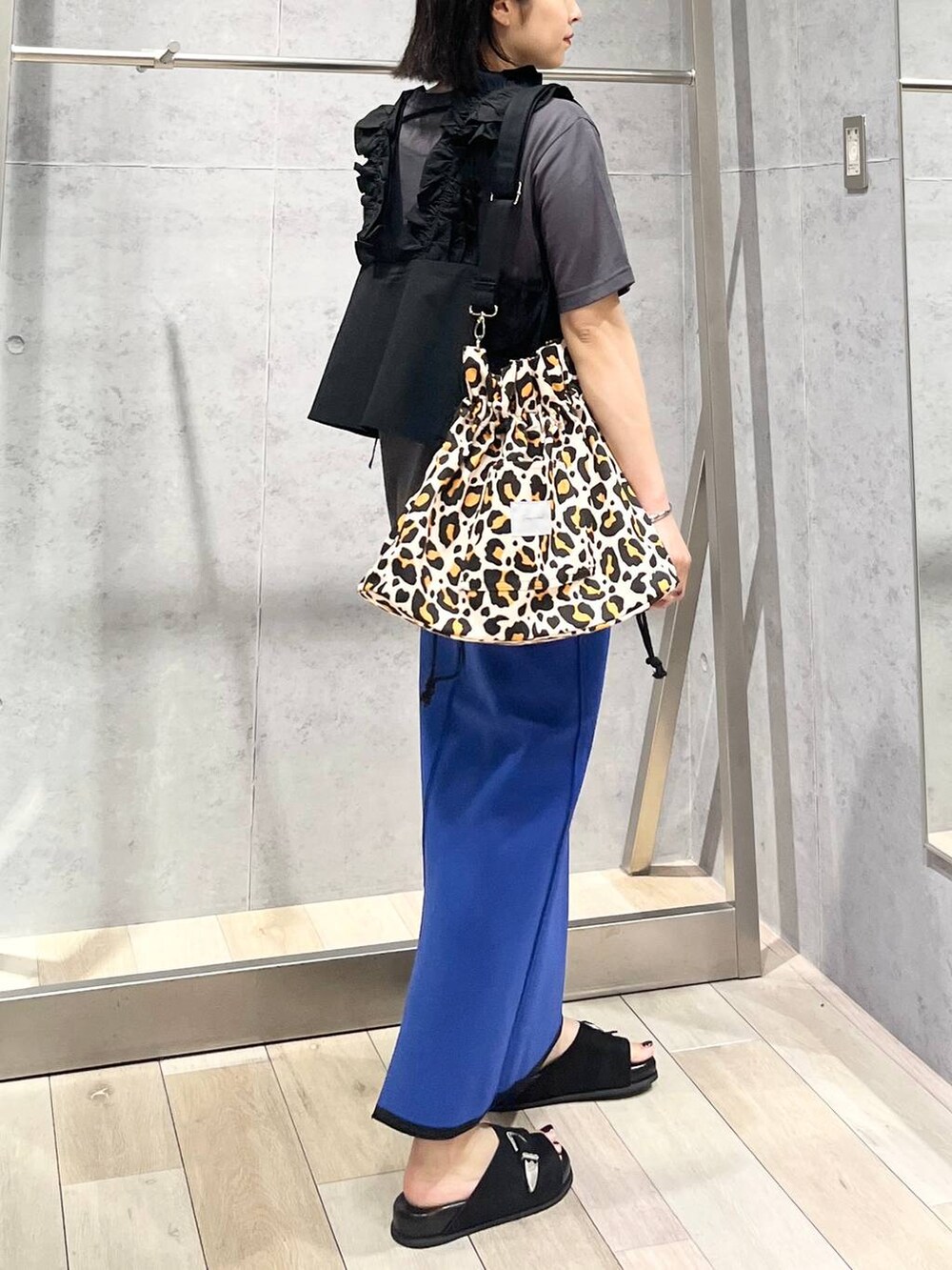 ブラック系のサンダル、ブラック系のベストを着用したレディースの夏コーディネートの4枚目の写真